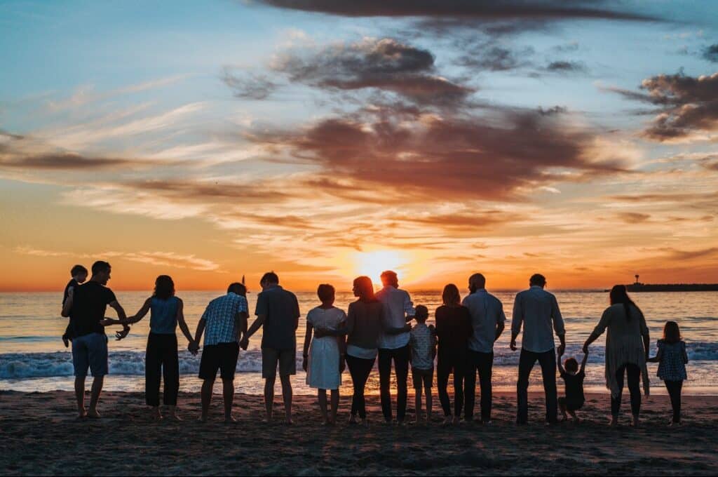 large family holding hands on the beach